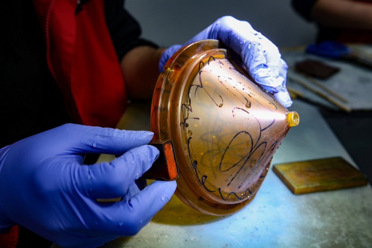 Wet sanding of chamber parts; black markers indicate untouched areas